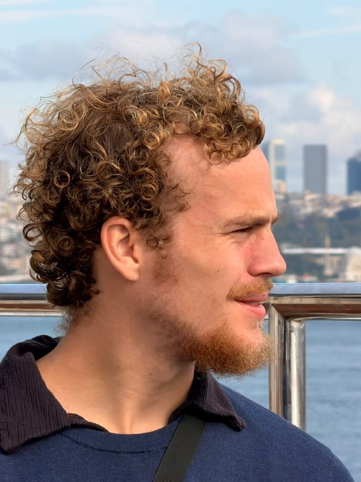 Bob Berghuis by the water, with the city skyline behind him